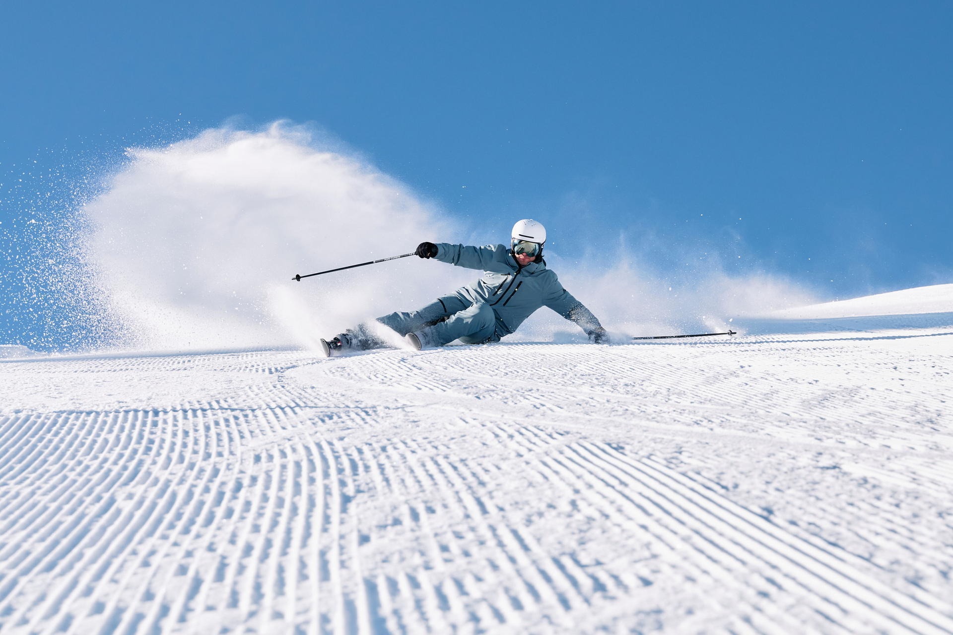 Skifahrer carvt die Piste runter, im Hintergrund ist eine Schneewolke.
